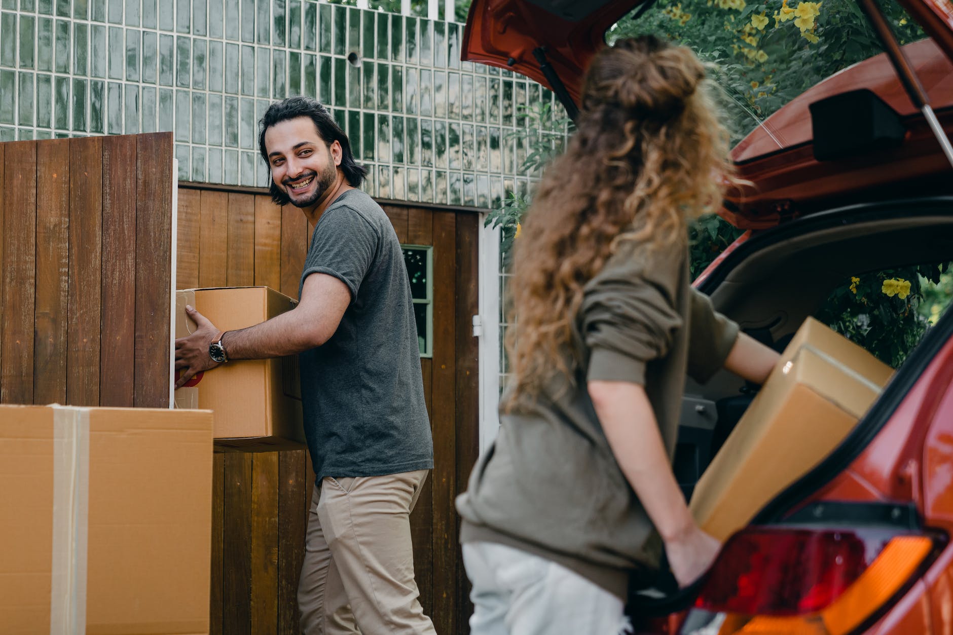 How to Buy a House for the First Time in 2023: A Comprehensive Guide 3 happy couple unloading automobile while moving apartment in summer day